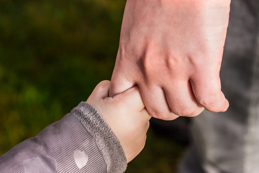 adult holding a child's hand